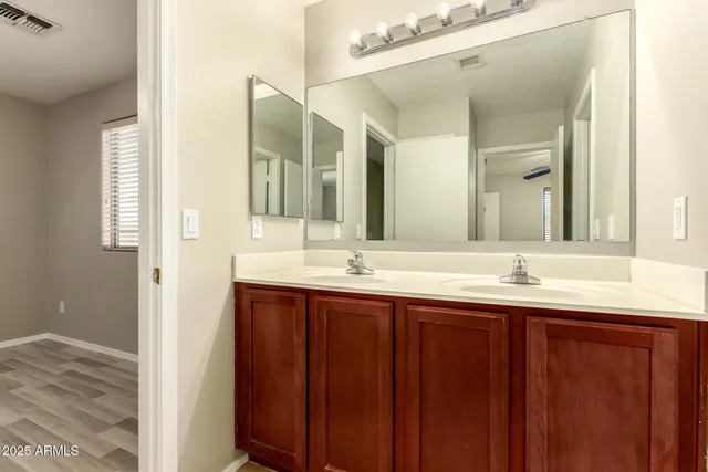 a bathroom with double sink and a mirror