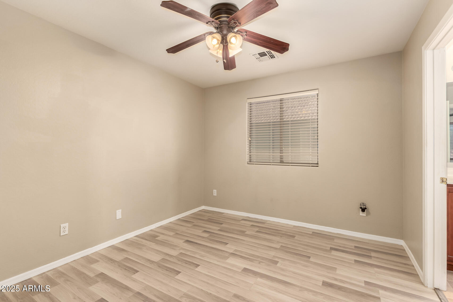 4403 West Maldonado Road Laveen, AZ 85339 - Photo 31 of 37 a view of empty room with wooden floor and fan