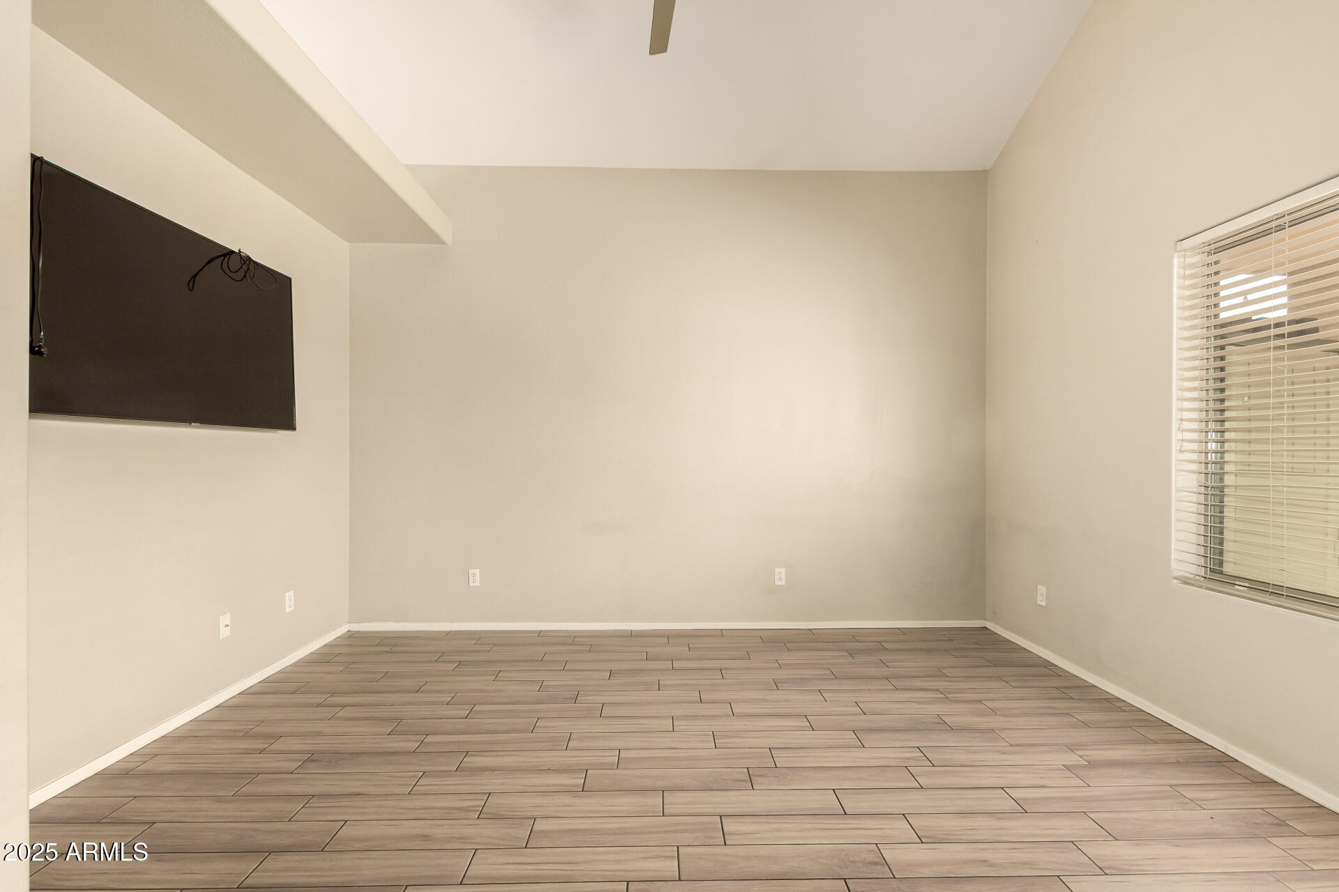 4403 West Maldonado Road Laveen, AZ 85339 - Photo 10 of 37 a view of an empty room with wooden floor and a window