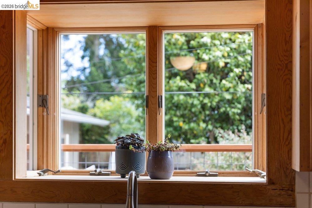 287 Purdue Avenue Kensington, CA 94708 - Photo 23 of 60 Double-hung casement windows featuring natural wood framing and trim above a white tile backsplash and a stainless steel faucet