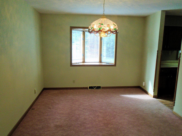 202 Linder Lane Rochelle, IL 61068 - Photo 4 of 17 an empty room with a chandelier fan and windows