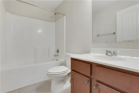 a bathroom with a granite countertop sink toilet a mirror and shower