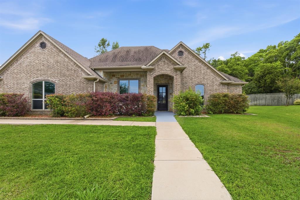 7765 Hickory Spring Lane Tyler, TX 75703 - Photo 1 of 38 Brick exterior with architectural gables, arched entry, and a contrasting dark front door