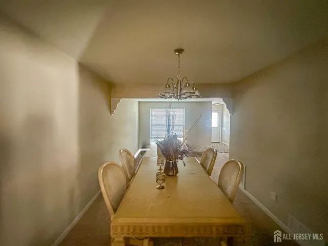 a view of a dining room with furniture and chandelier