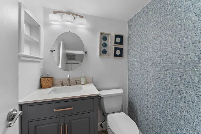 a bathroom with a toilet sink and mirror