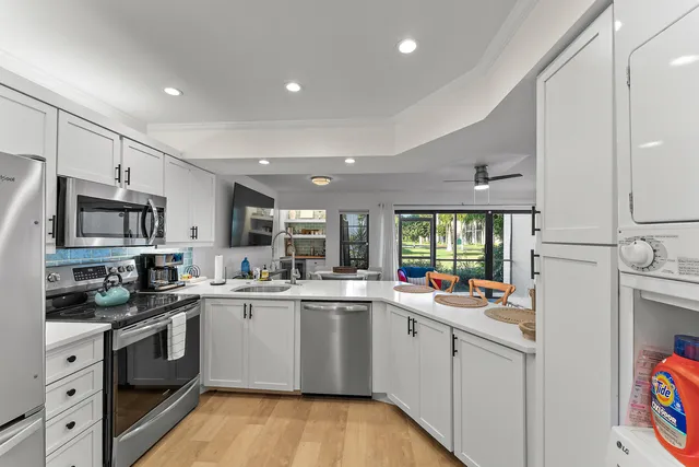 a kitchen with stainless steel appliances a sink window and cabinets