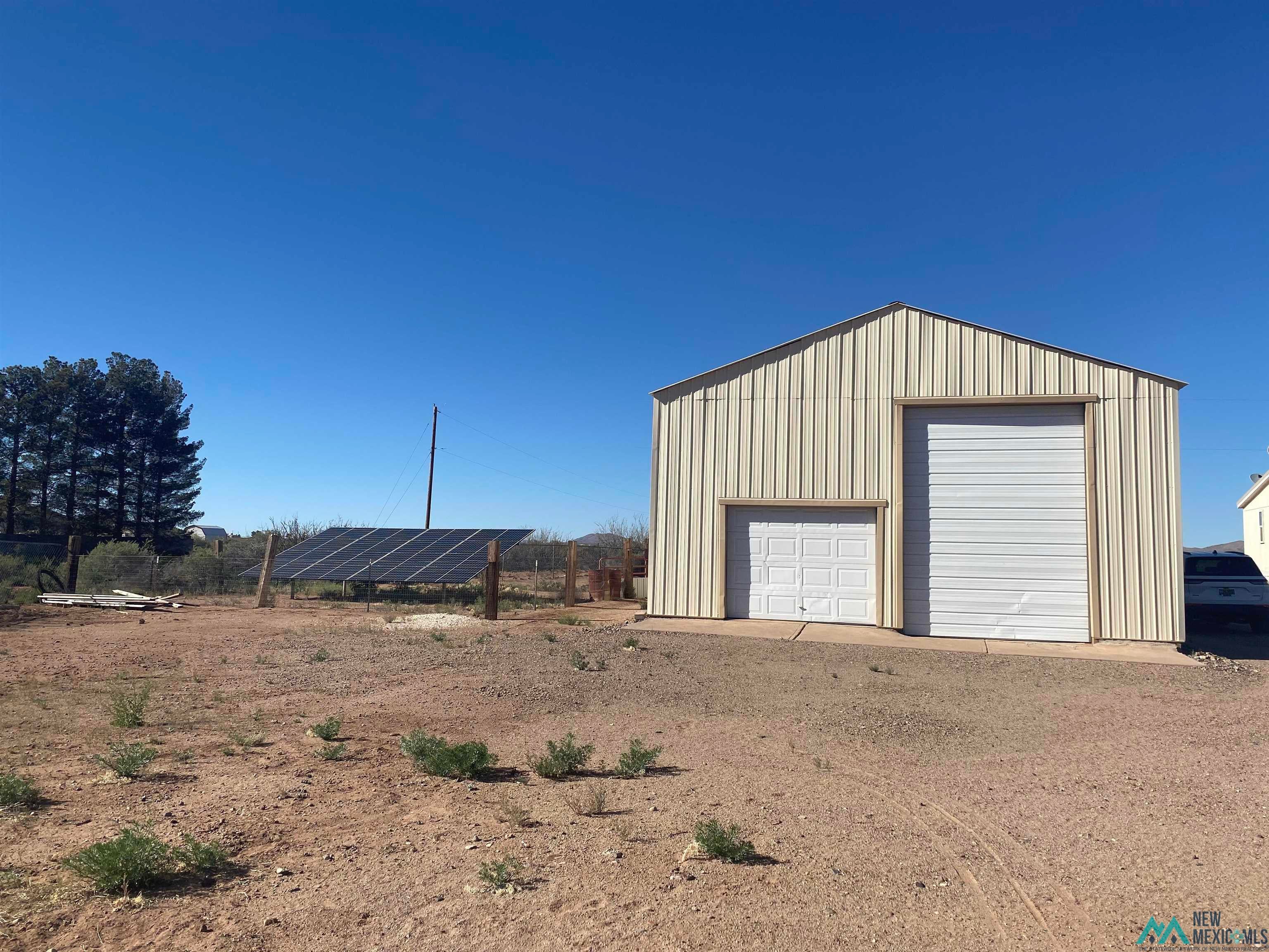465 Irritabe Road Northeast Deming, NM 88030 - Photo 2 of 24 Detached garage featuring ground mounted solar panels