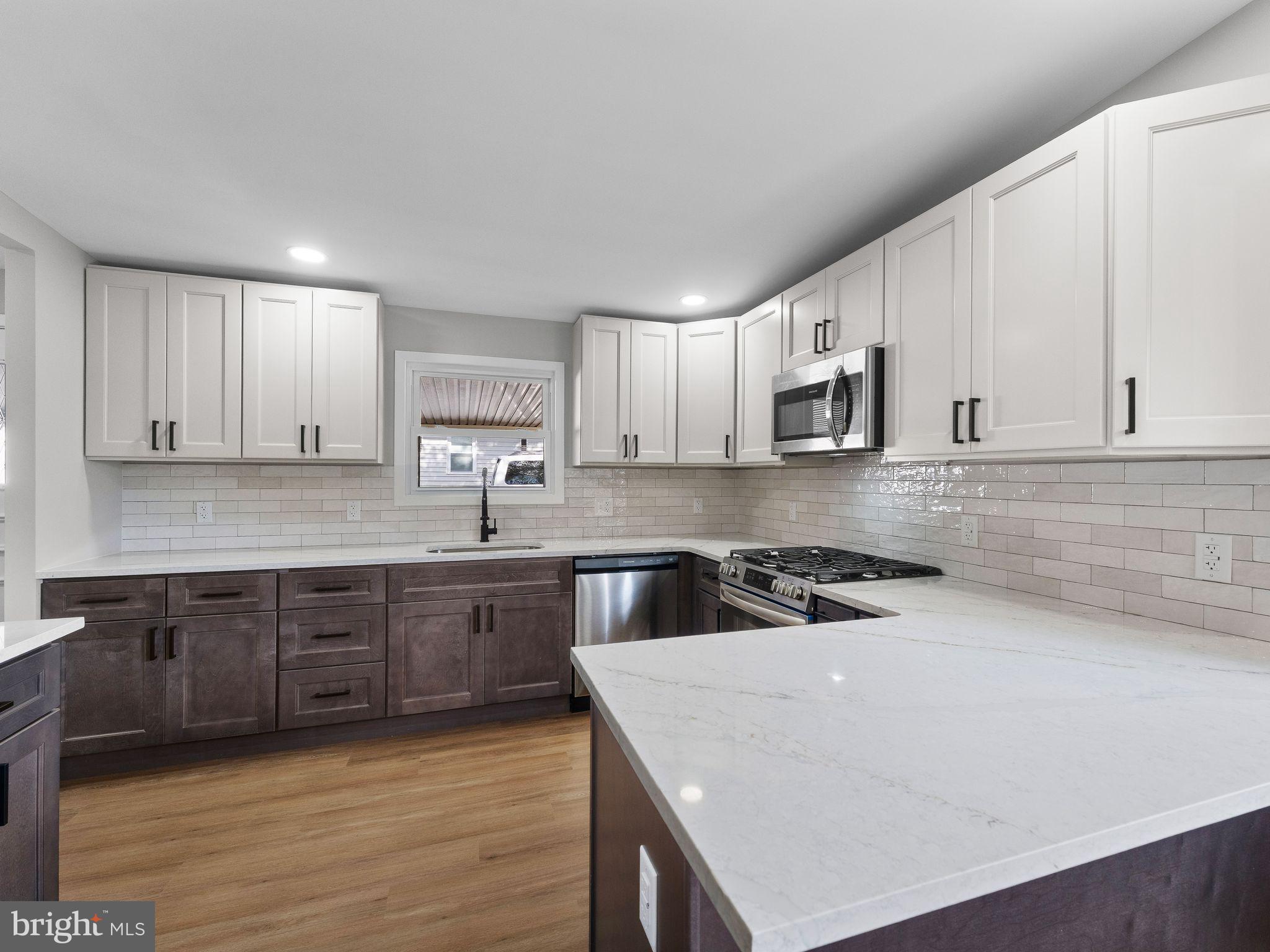 9314 Trout Road Philadelphia, PA 19115 - Photo 1 of 23 a kitchen with stainless steel appliances granite countertop a stove a sink a microwave a refrigerator and cabinets