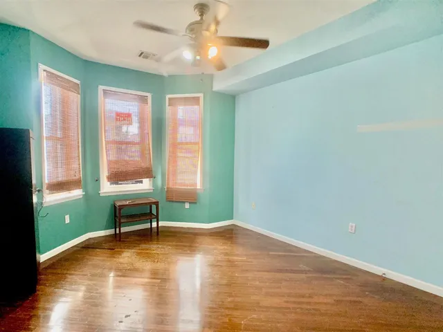 a view of room with window ceiling fan and hardwood floor