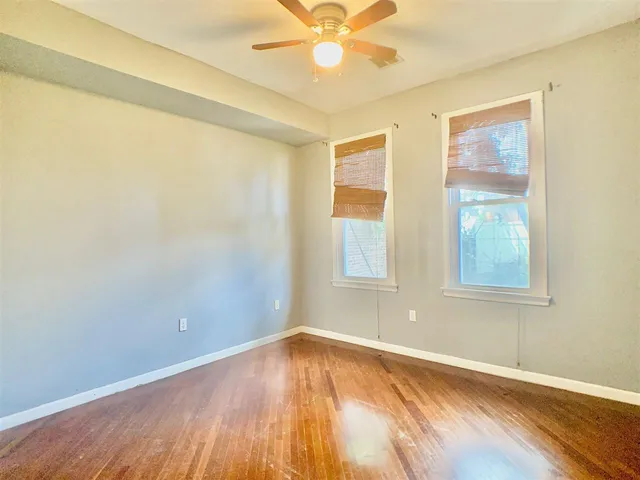an empty room with a window and wooden floor
