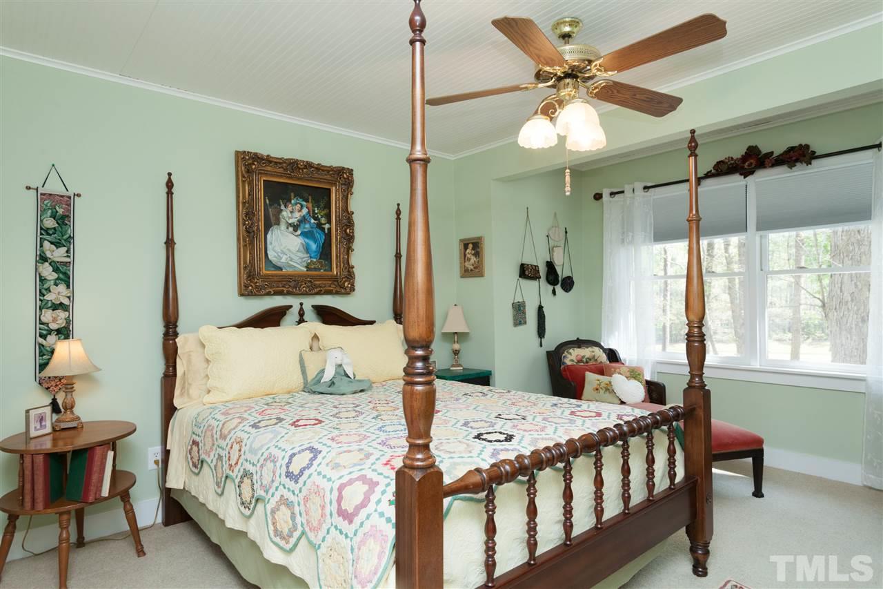 7016 Farmdale Road Raleigh, NC 27610 - Photo 14 of 25 a bedroom with a bed a chandelier and a mirror