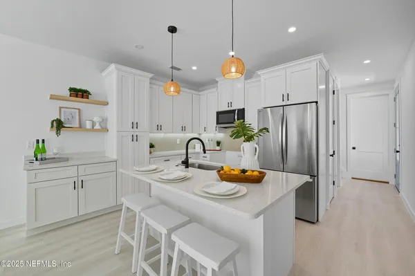 a kitchen with a sink a counter space and a wooden floor