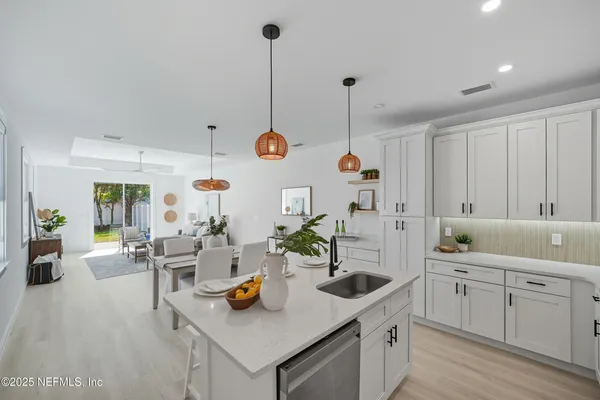 a kitchen with white cabinets and sink
