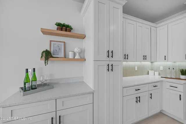 a dining room with stainless steel appliances kitchen island granite countertop a table chairs and a refrigerator