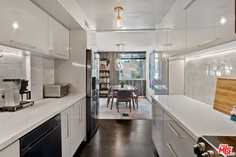 a large kitchen with a table chairs refrigerator and cabinets