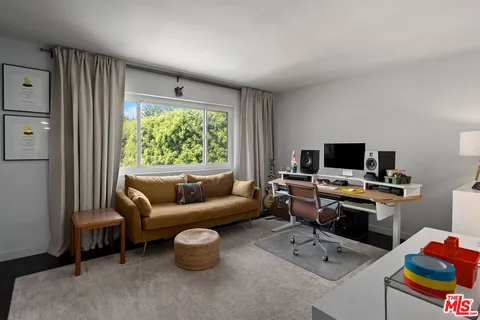 a view of a livingroom with workspace and a window