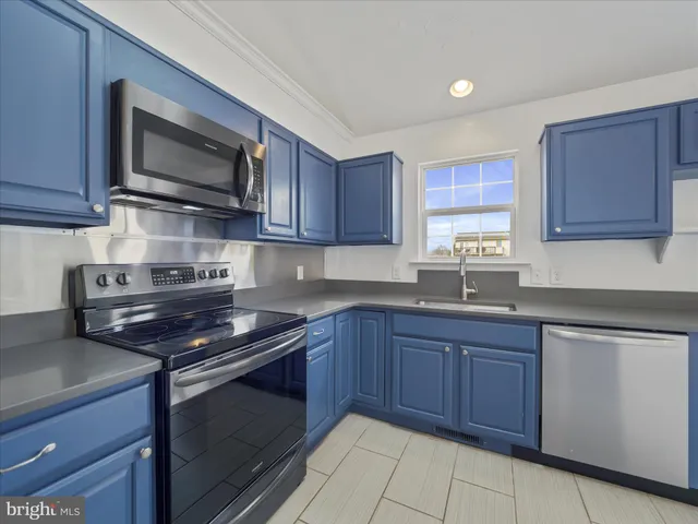 a kitchen with stainless steel appliances granite countertop wooden cabinets stove top oven and microwave