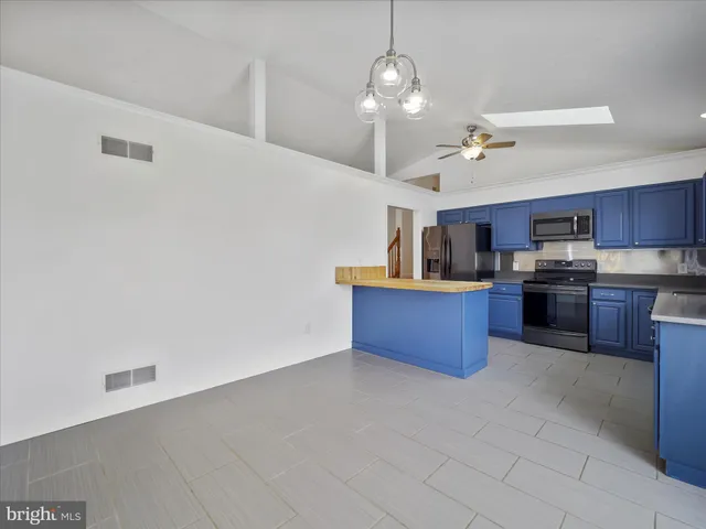 a kitchen with stainless steel appliances a refrigerator and a wooden cabinets