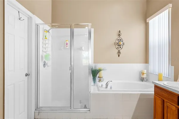 a bathroom with a tub a sink double vanity and mirror
