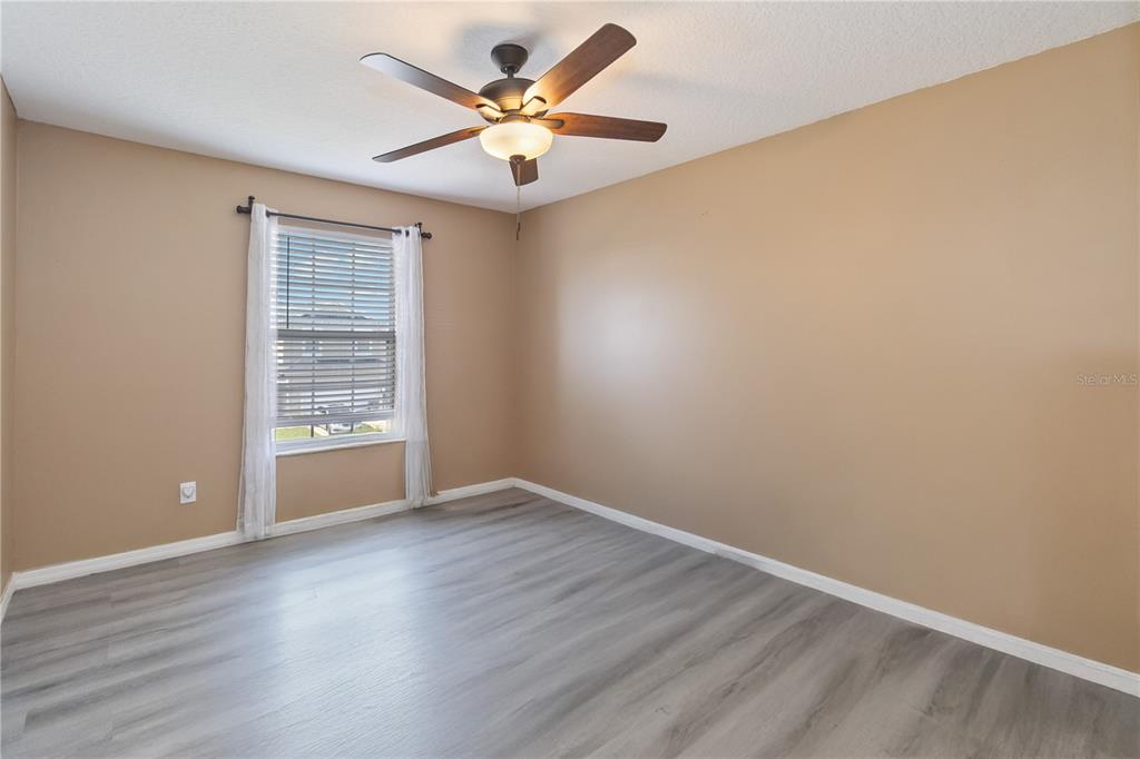 2327 Andrews Valley Drive Kissimmee, FL 34758 - Photo 31 of 42 an empty room with wooden floor and windows