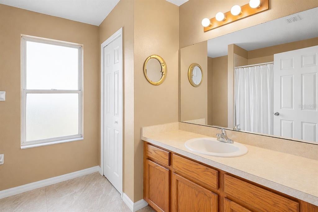 2327 Andrews Valley Drive Kissimmee, FL 34758 - Photo 33 of 42 a bathroom with a sink a mirror and a window