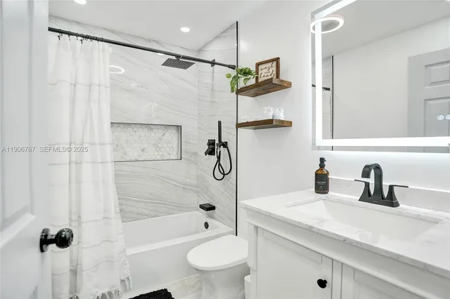 a bathroom with a granite countertop sink a toilet and shower