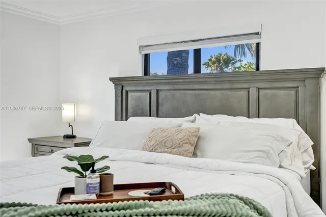 a bed sitting in a bedroom and painting on the wall