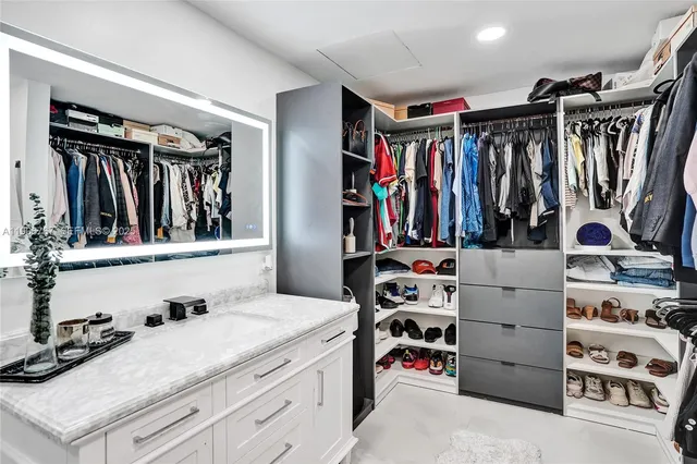 a view of walk in closet with clothes and shoes