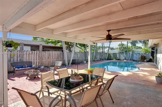 a view of a patio with a dining table and chairs with a small yard
