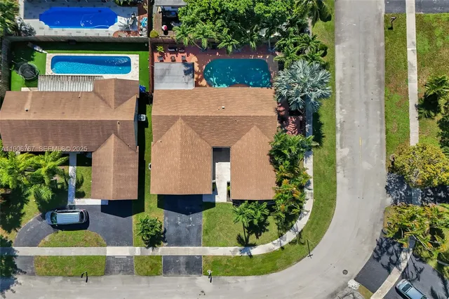 an aerial view of residential houses with outdoor space and parking