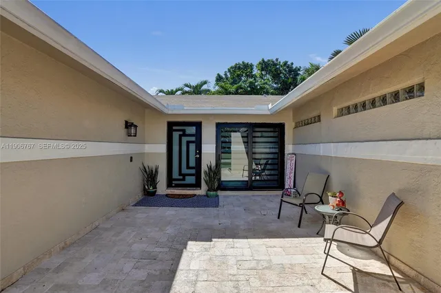 a view of a patio with table and chairs and potted plants