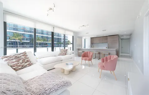 a living room with furniture and a floor to ceiling window
