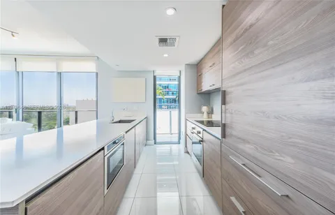 a view of a kitchen with a sink and wooden floor