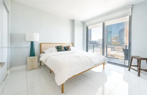 a bedroom with a bed and a large window