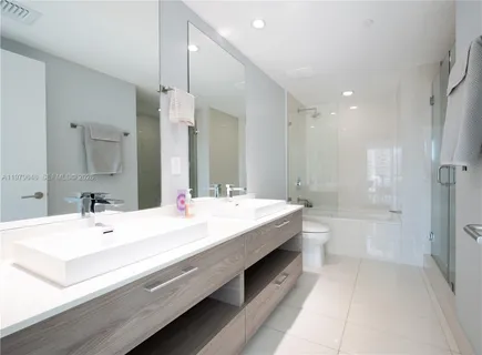 a bathroom with a double vanity sink mirror double and bathtub