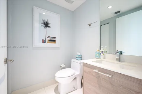a bathroom with a toilet a sink a mirror and vanity