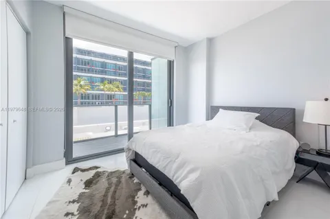 a large bed sitting in a bedroom next to a window
