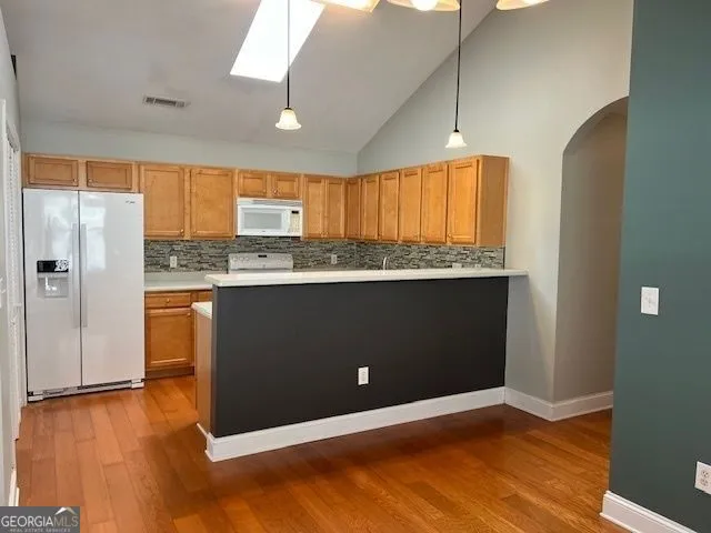 a kitchen with stainless steel appliances granite countertop a refrigerator a sink and a stove