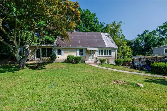 a view of a house with a yard and sitting area
