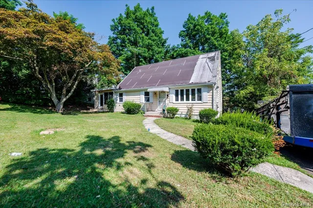 a front view of a house with a garden and yard