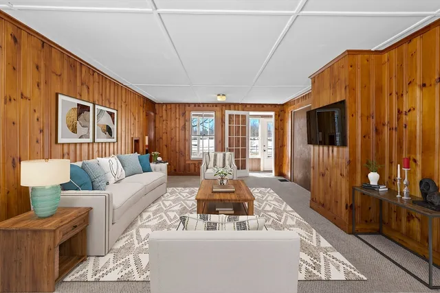 a living room with furniture a flat screen tv and a large window