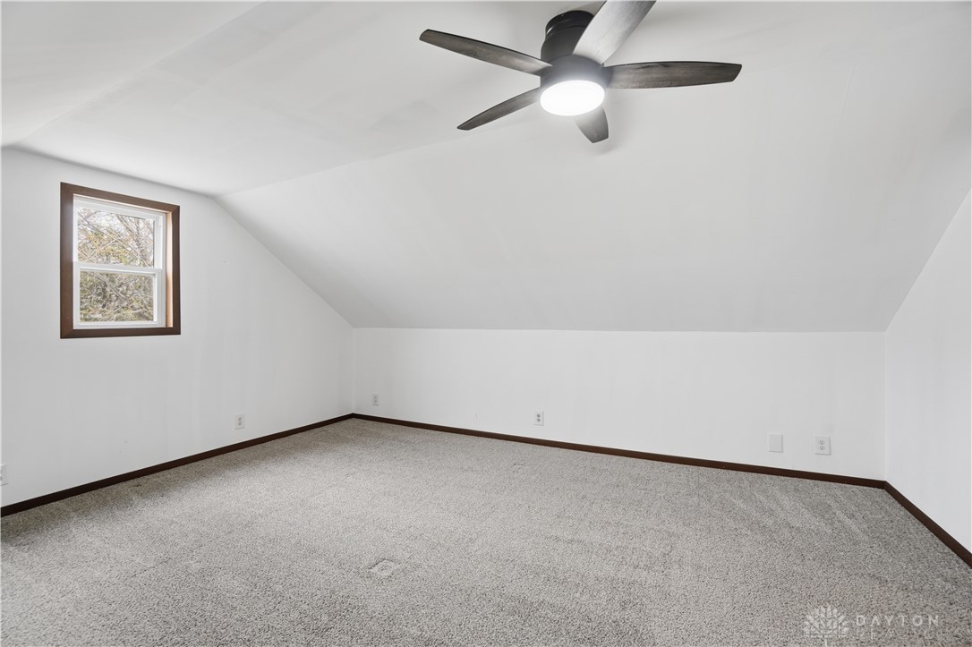7553 Coffin Station Road Springfield, OH 45502 - Photo 71 of 95 This spacious room features vaulted ceilings, a window, and soft carpet flooring.