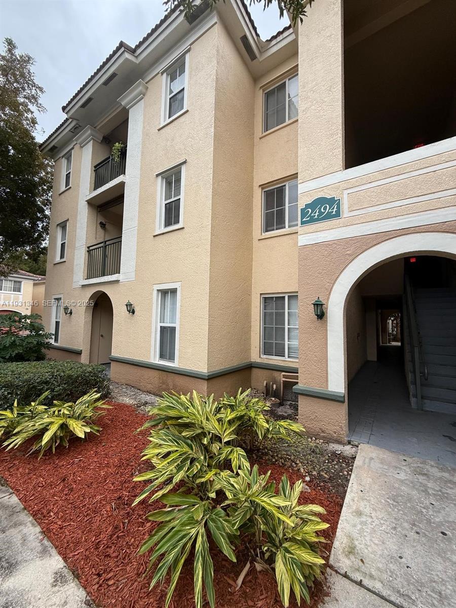 2494 Centergate Drive, Unit 201 Miramar, FL 33025 - Photo 2 of 20 a front view of a house with garden