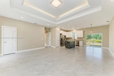 an empty room with furniture and a view of kitchen