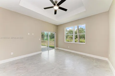 an empty room with windows and ceiling fan