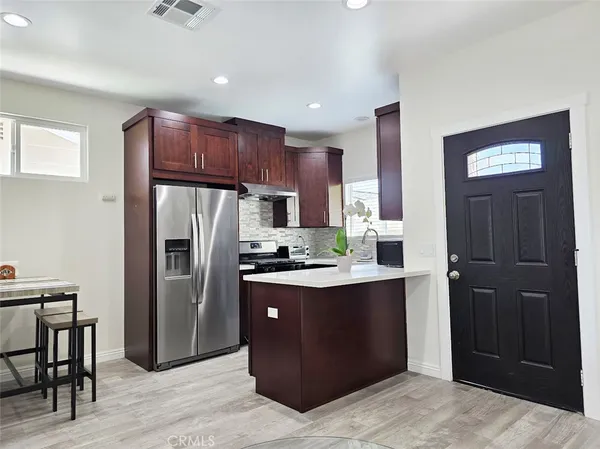a kitchen with stainless steel appliances granite countertop a refrigerator a stove a sink and a refrigerator