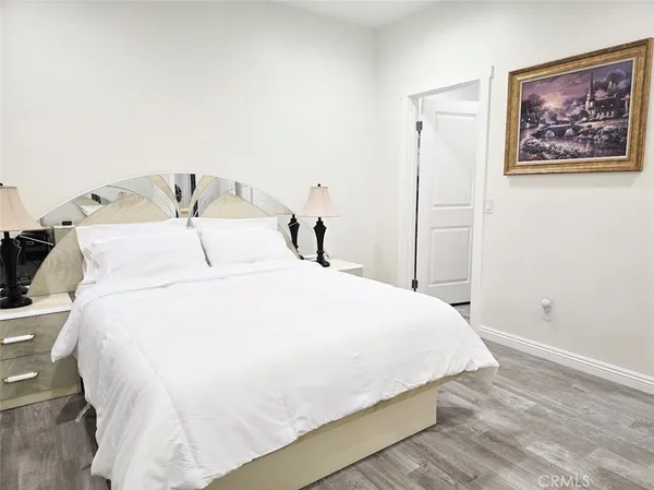 a bedroom with a bed and a painting on the wall