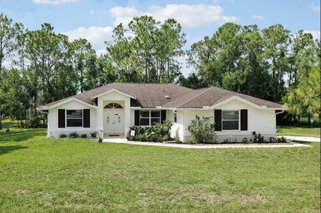 a front view of house with yard and green space