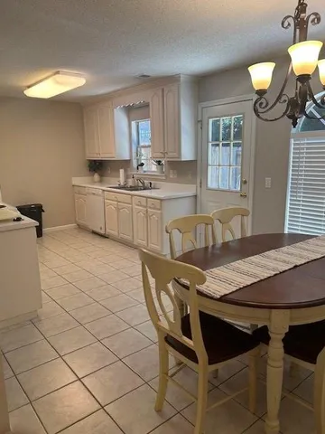 a kitchen with a table chairs sink and cabinets