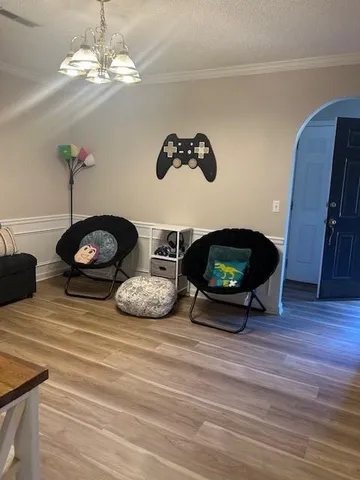 a living room with furniture and a chandelier